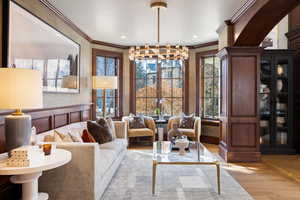 Living room featuring crown molding, light hardwood / wood-style flooring, and a chandelier