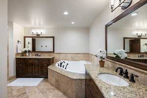 Bathroom with tiled tub and vanity