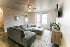 Living room with plenty of natural light, dark hardwood / wood-style flooring, and a textured ceiling