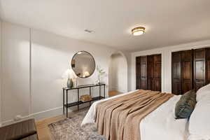 Bedroom with multiple closets and light wood-type flooring