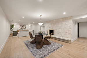 Dining space featuring a stone fireplace and light wood-type flooring