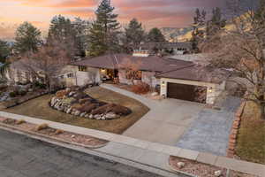 View of front of house featuring a garage, a mountain view, and a yard