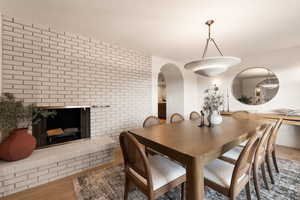 Dining room with hardwood / wood-style floors and a brick fireplace