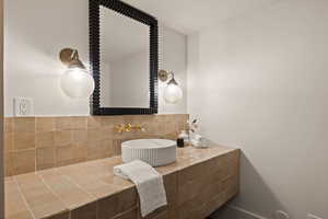 Bathroom featuring tasteful backsplash and sink