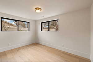 Spare room featuring plenty of natural light and light hardwood / wood-style floors