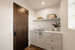 Bar featuring sink and gray cabinetry