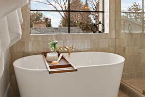 Bathroom with a washtub and tile walls