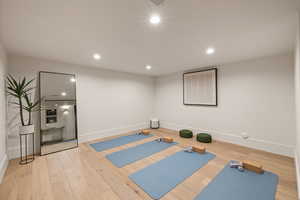 Exercise room with hardwood / wood-style flooring