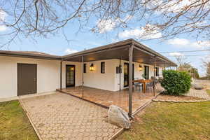 Back of property featuring a yard and a patio area