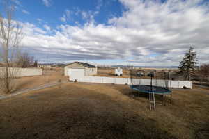 View of yard with 2 car garage and additional parking