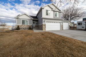 View of front facade featuring a 3 car garage and a front lawn with additional space for parking