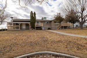 View of back of home with 2 decks and a covered patio