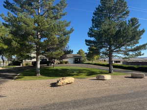 Summer View of home with mature trees, xeriscaping, landsaping