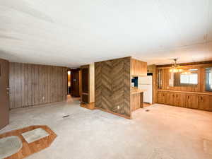 Unfurnished living room with ceiling fan and wood walls