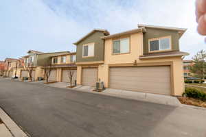 View of front of house with a garage and central air condition unit