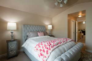 Bedroom featuring vaulted ceiling, carpet, and ceiling fan