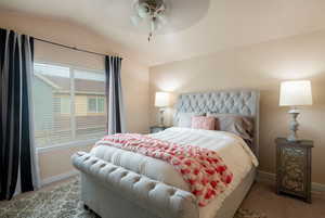 Bedroom featuring ceiling fan, lofted ceiling, and light carpet