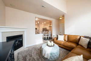 Carpeted living room featuring an inviting chandelier and a fireplace