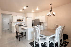 Dining room featuring an inviting chandelier, sink, and light tile patterned floors