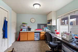 Office featuring light colored carpet and built in desk