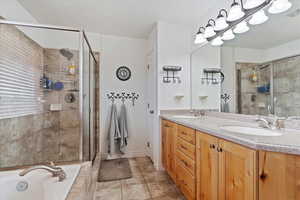 Bathroom featuring tile patterned floors, vanity, and plus walk in shower