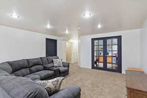 Living room with french doors, carpet flooring, and a textured ceiling