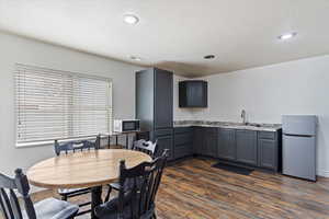 Dining room featuring a healthy amount of sunlight, sink, dark wood-type flooring, and a textured ceiling