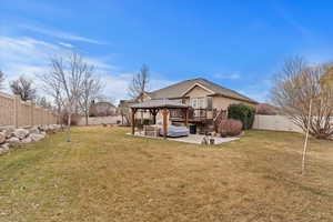 Back of property featuring a yard, a gazebo, a patio, and a deck