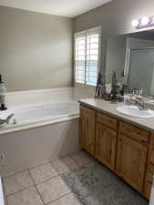 Bathroom with tile patterned floors, vanity, and a tub