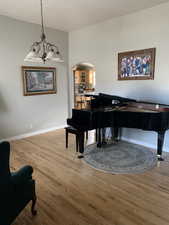 Miscellaneous room with hardwood / wood-style flooring and a chandelier