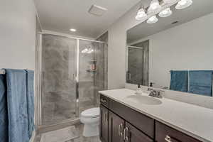 Bathroom with vanity, toilet, and a shower with door