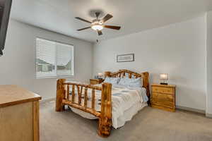 Carpeted bedroom featuring ceiling fan