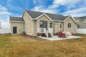 Back of house with a yard, central AC, and a patio