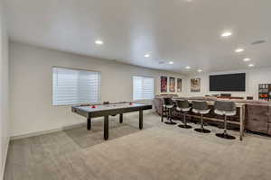 Playroom featuring indoor bar and light carpet