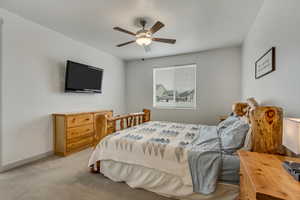 Carpeted bedroom featuring ceiling fan