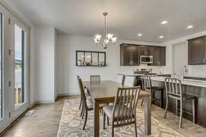 Dining room featuring a chandelier, sink, and light wood-type flooring