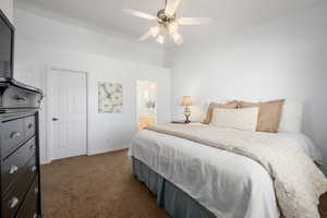 Carpeted bedroom featuring ceiling fan and connected bathroom