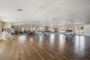 Unfurnished dining area with vaulted ceiling, dark wood-type flooring, and a textured ceiling