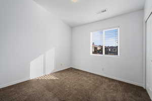 Spare room with dark colored carpet