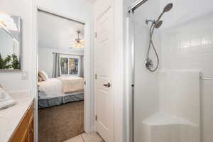 Bathroom featuring vanity, tile patterned floors, ceiling fan, and walk in shower