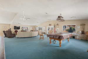 Game room featuring lofted ceiling, ceiling fan, carpet flooring, a textured ceiling, and pool table