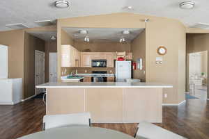 Kitchen with electric range, light brown cabinets, dark hardwood / wood-style floors, and white fridge