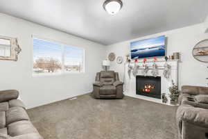 Living room featuring carpet flooring and a tiled fireplace