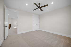 Unfurnished bedroom featuring light carpet and ceiling fan