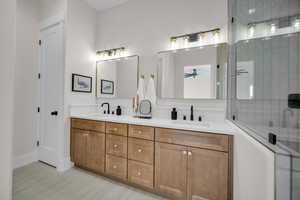 Bathroom featuring ceiling fan, vanity, and an enclosed shower