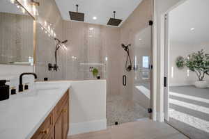 Bathroom with vanity, tile patterned floors, and a shower with door