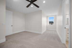 Carpeted spare room featuring ceiling fan