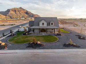 View of front of property featuring a mountain view, a front yard, and a porch