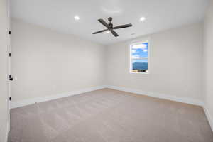 Unfurnished room featuring light colored carpet and ceiling fan