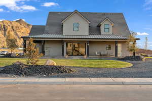 View of front of property with covered porch and a front lawn